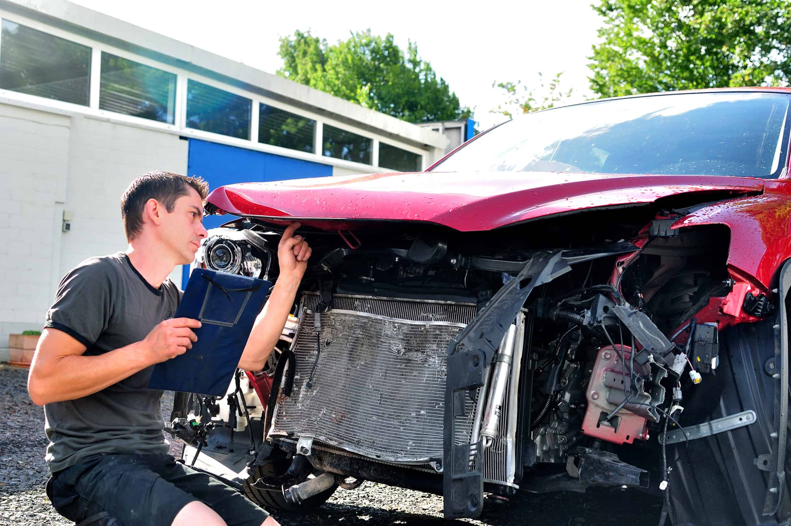 man Inspecting car damage after crash.