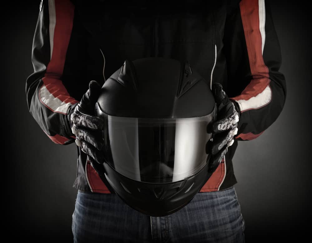 motorcyclist holds a helmet
