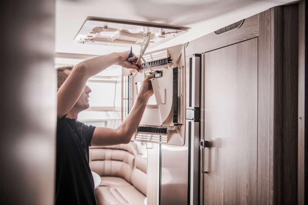 technician fixing broken ac