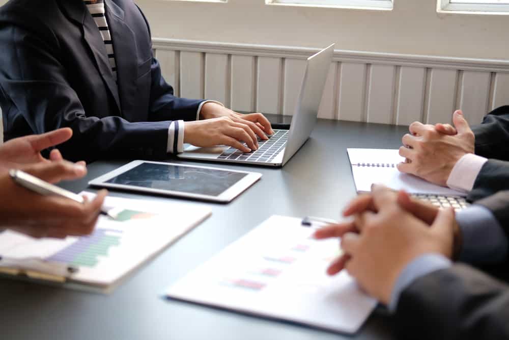 employees discussing on the table with laptop and papers