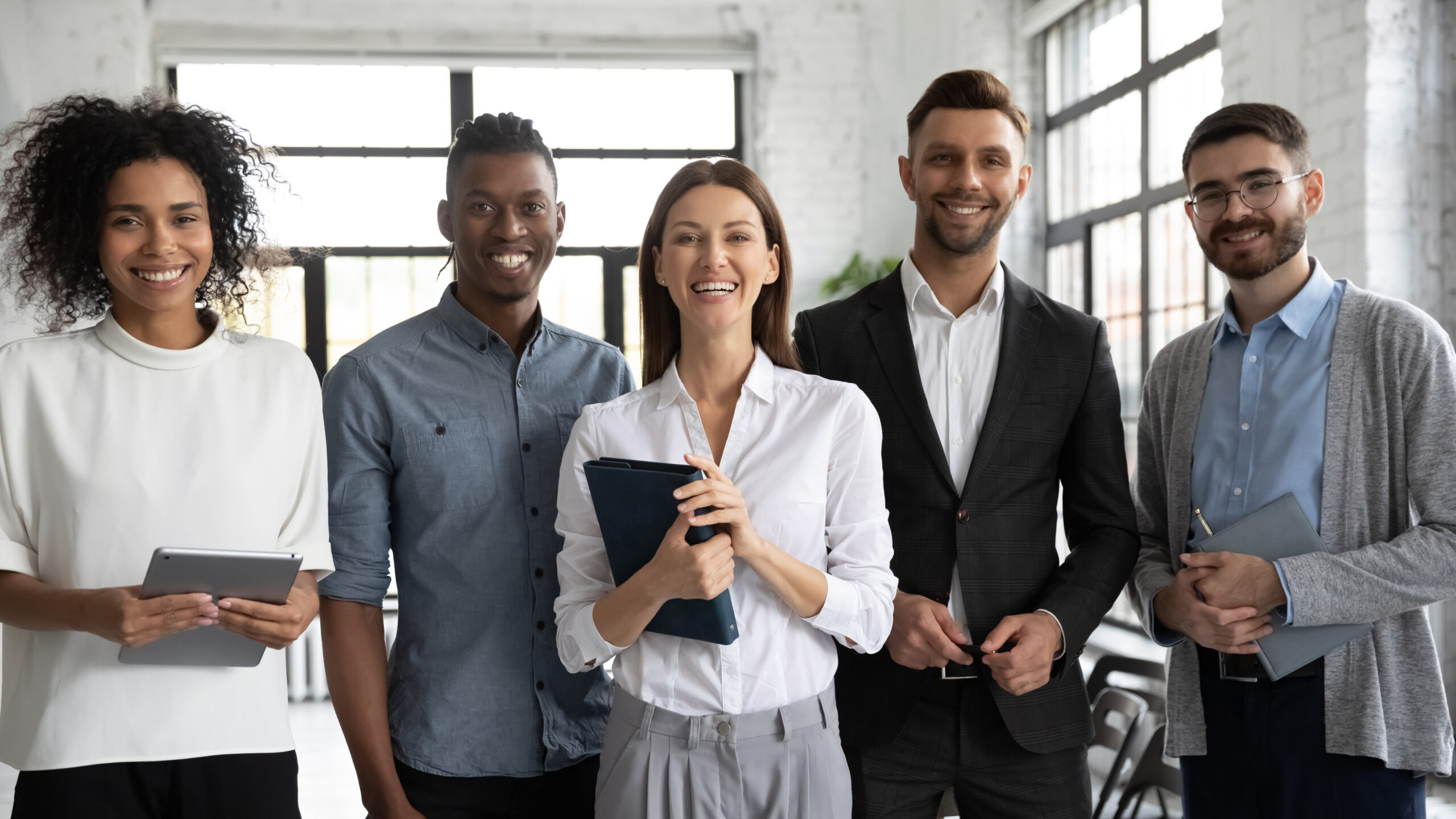 five smiling employees standing