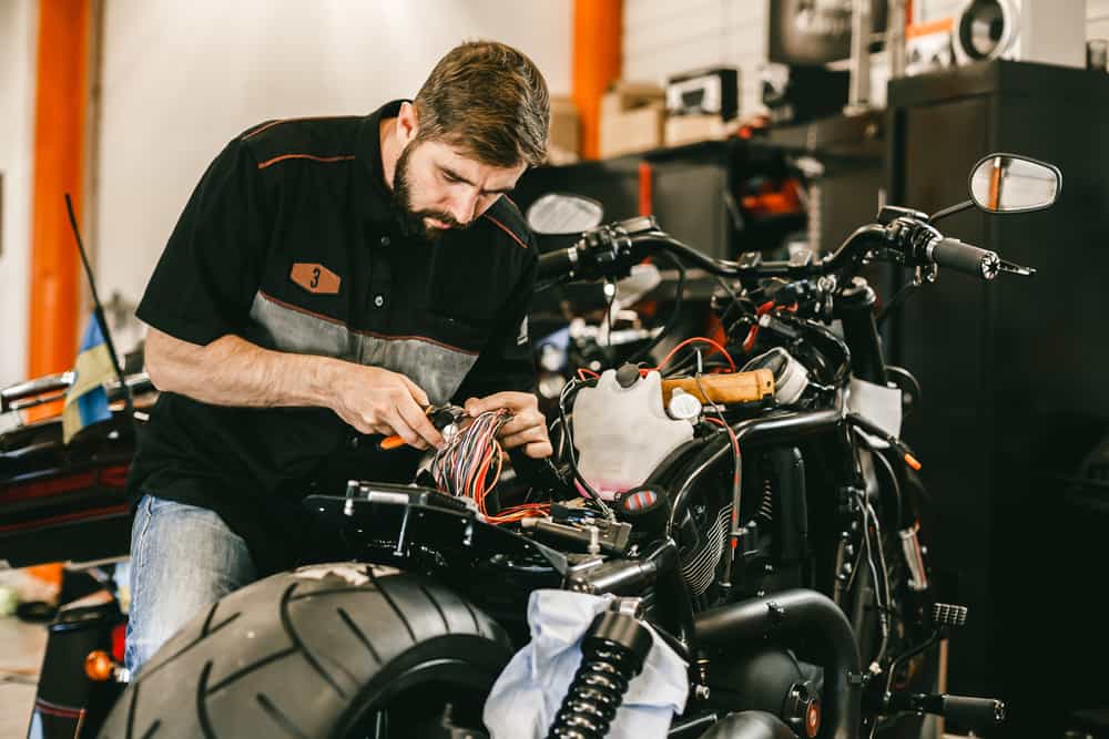 mechanic checking a motorbike wiring